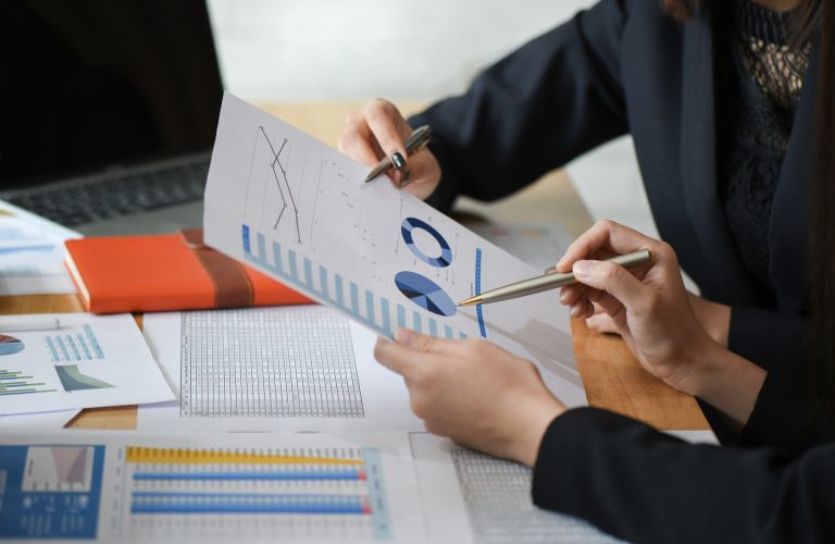 Female accountant team is analyzing data documents in the office